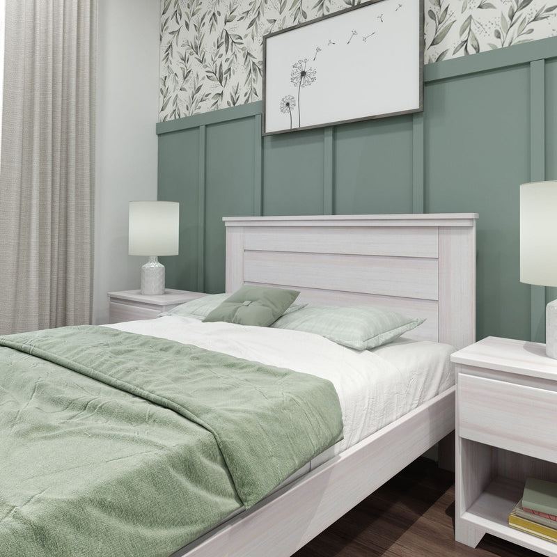 Modern farmhouse bedroom with sage green board-and-batten accent wall, botanical wallpaper, whitewashed wood bed frame, matching nightstands and lamps, and soft green bedding
