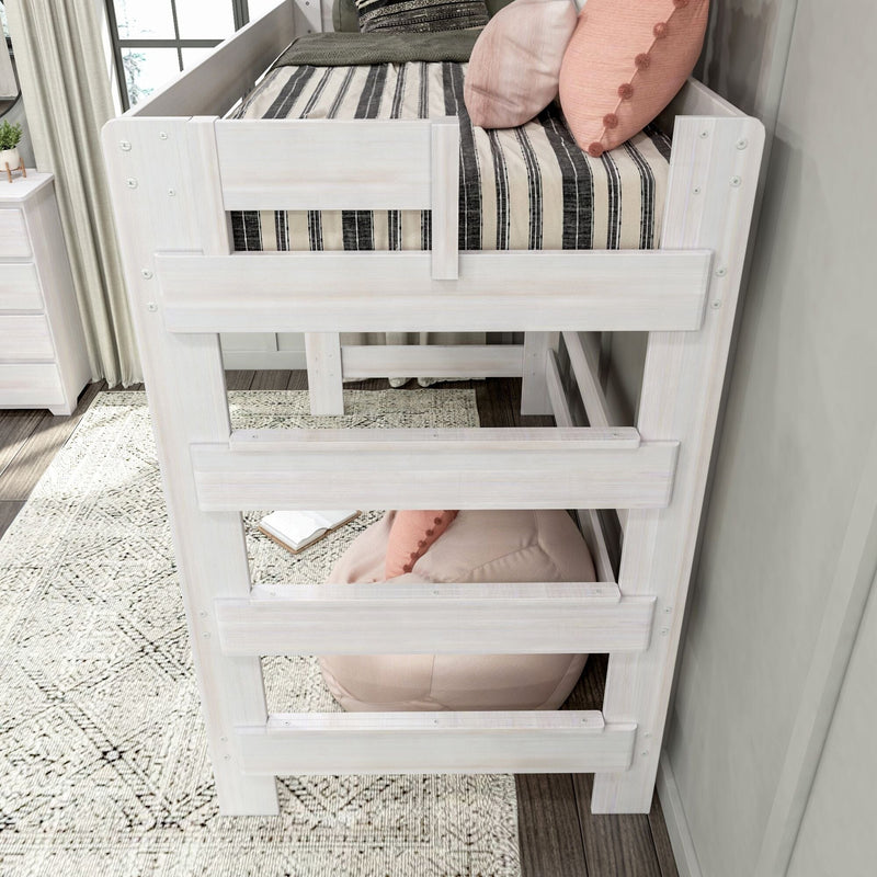 Whitewashed wooden loft bed with striped bedding, pink decorative pillows and built-in ladder in modern farmhouse kids bedroom