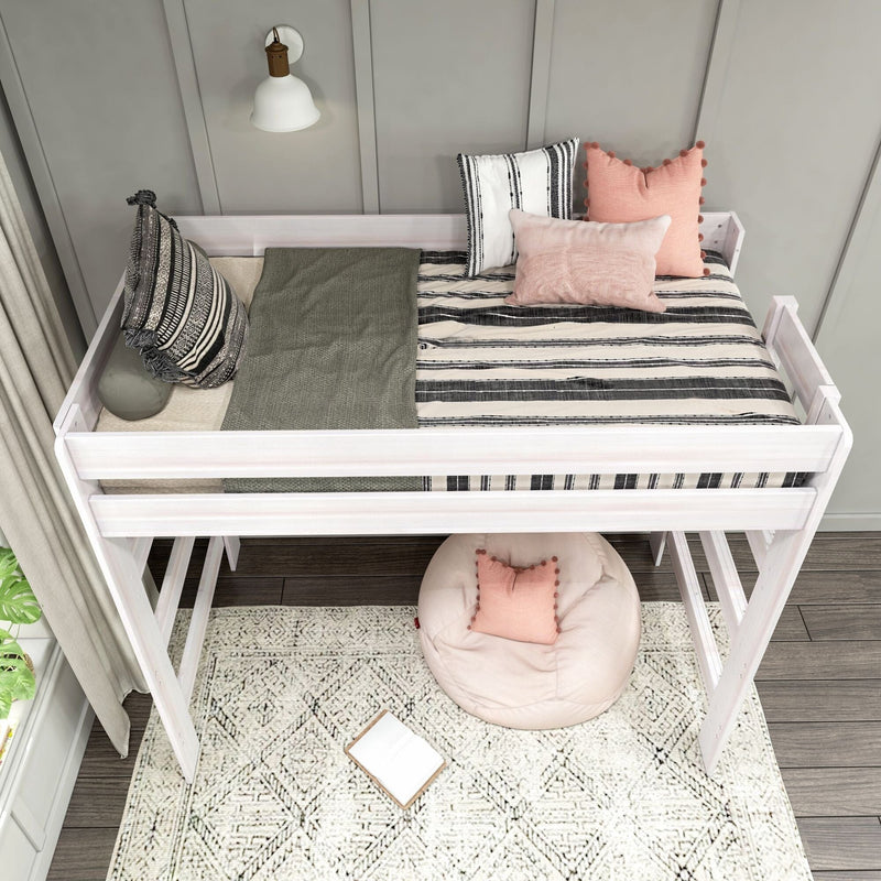 White wooden loft bed with black-and-white striped bedding, pink pom-pom and boho throw pillows, cozy kids' reading nook with round beanbag, patterned rug and wall sconce