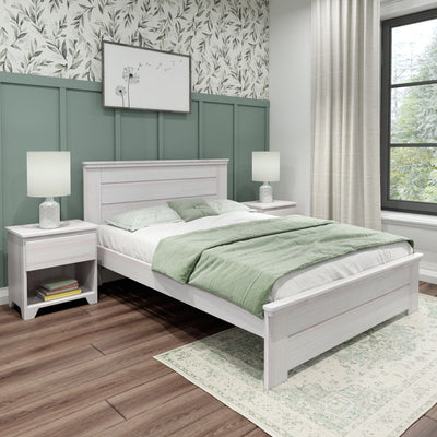 Modern farmhouse bedroom with whitewashed wooden bed, sage green wainscoting, botanical wallpaper, green bedding, bedside lamps, area rug and wood plank floor