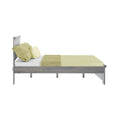 Gray wooden platform bed with light green textured bedding, coordinating pillows and throw runner