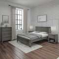 Modern farmhouse bedroom with gray wood bedframe, hardwood floors, neutral bedding, sheer curtains and floral wallpaper.