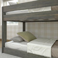 Gray reclaimed wood twin-over-twin bunk bed with white bedding, green pillows and neutral plaid wallpaper in rustic kids' bedroom