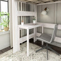 Whitewashed loft bed with built-in desk and grey swivel chair, cozy bedroom workspace with potted plant, wall lamp and pencils