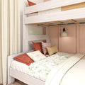 Light wood loft bunk bed with coral pillows and floral duvet in a cozy kids' bedroom reading nook with wall lamp