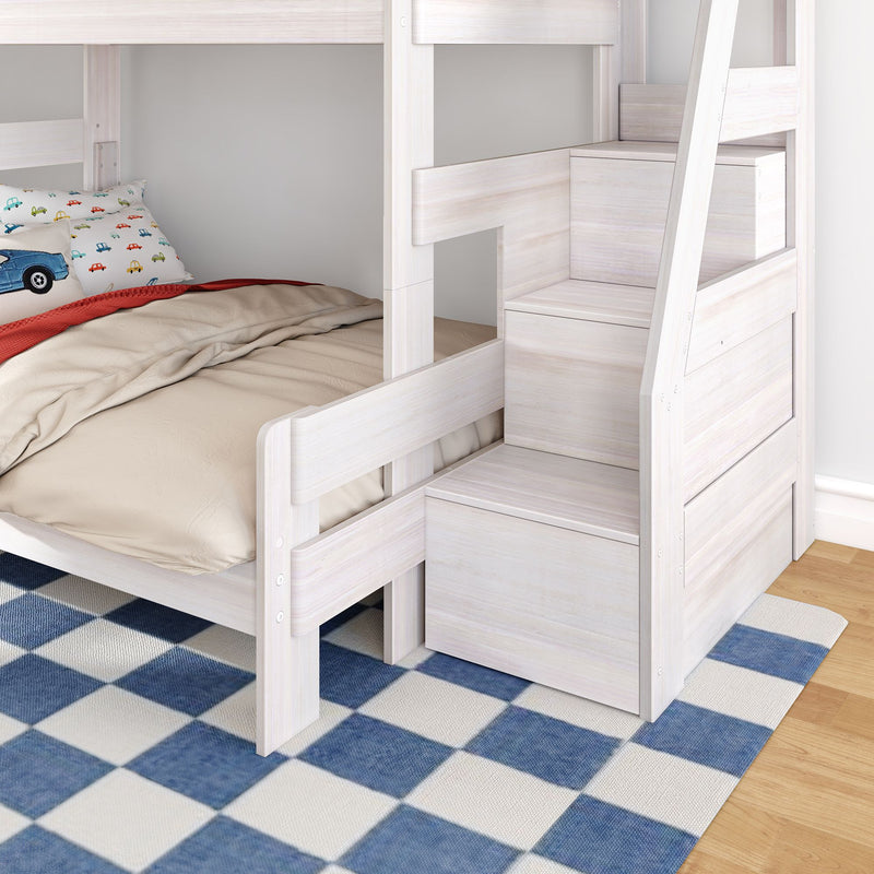 Space-saving whitewashed wooden kids bunk bed with built-in storage stairs, lower bed with car-print pillow, beige bedding and blue check rug