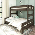 Dark wood bunk bed with guardrails and layered bedding in a modern teal-paneled kids' bedroom featuring cream curtains, patterned rug and wall sconces