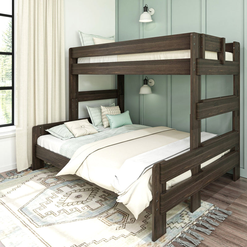 Dark wood bunk bed with guardrails and layered bedding in a modern teal-paneled kids' bedroom featuring cream curtains, patterned rug and wall sconces