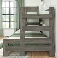 Rustic gray wooden twin-over-twin bunk bed with green bedding in a modern farmhouse bedroom beside a black-grid window and wall sconce