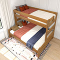 Wooden twin-over-full bunk bed with cream bedding, rust-red throws, navy runner and decorative pillows on a patterned rug in a sunlit modern bedroom