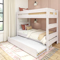 Whitewashed wooden bunk bed with pull-out trundle, neutral bedding and rust throw pillows in a cozy modern kids' bedroom with pink paneled wall and wall sconce