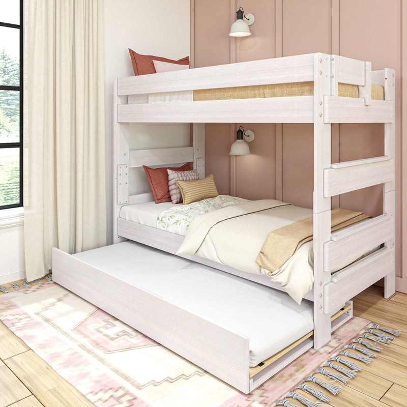Whitewashed wooden bunk bed with pull-out trundle, neutral bedding and rust throw pillows in a cozy modern kids' bedroom with pink paneled wall and wall sconce