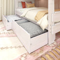 Whitewashed wood bunk bed with under-bed storage drawers and pull-out trundle mattress, neutral beige bedding and patterned pillows in cozy bedroom