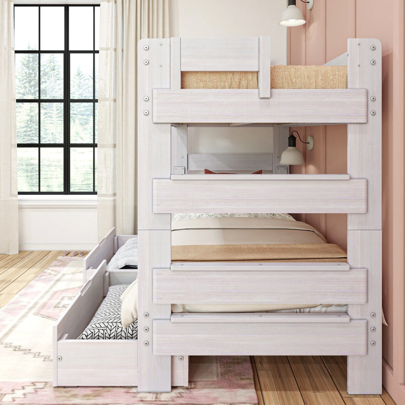 Whitewashed wooden bunk bed with pull-out trundle and storage drawers in a bright girls' bedroom with large grid window, neutral bedding, and a wall-mounted lamp