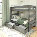 Gray wooden bunk bed with pull-out trundle storage drawers, green bedding and patterned pillows in a modern farmhouse bedroom with wall lamps and green curtains