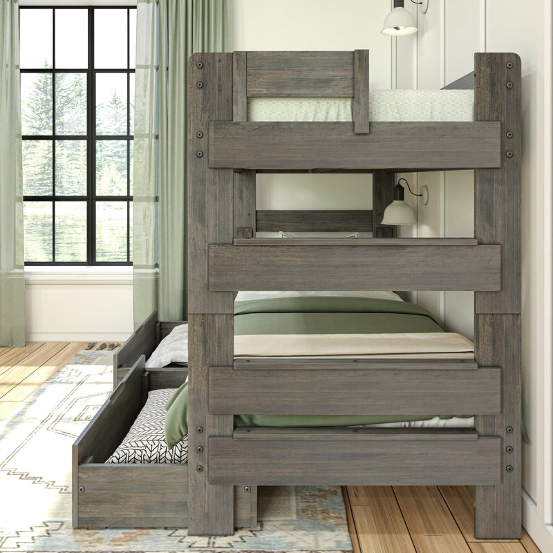 Rustic gray twin-over-twin wooden bunk bed with trundle drawer, green bedding and built-in guardrail in a bright farmhouse bedroom