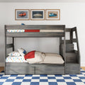 Gray wooden bunk bed with stairs and storage, car-print bedding, red throw, framed vintage car prints and blue checkered rug