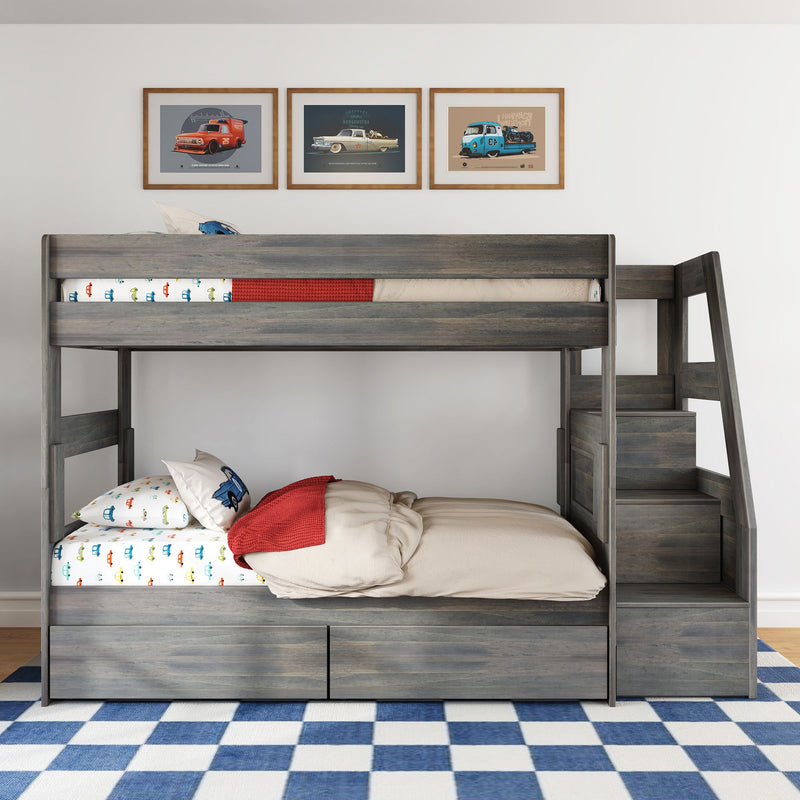 Gray wooden bunk bed with stairs and storage, car-print bedding, red throw, framed vintage car prints and blue checkered rug