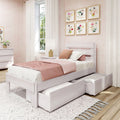 Pink bedroom decor featuring a white wooden platform bed with under-bed storage drawers, pink bedding and textured pillows, floral gallery wall art, white curtains and bedside lamp — cozy modern girls’ room.