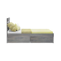 Modern grey wood twin bed frame with under-bed storage drawers, pale yellow sheets and decorative pillows on white background