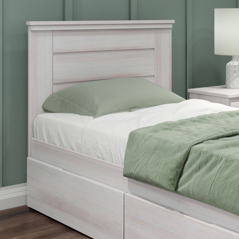 Whitewashed wooden platform twin bed with built-in underbed storage drawers, sage green bedding, matching nightstand and lamp in modern bedroom