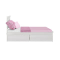 Modern white wooden twin bed with pink fitted sheet, textured pink throw blanket and pillows, and under-bed storage drawers