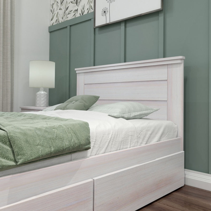 Modern bedroom with whitewashed wooden bed frame, green board-and-batten accent wall, coordinated green bedding and bedside lamp