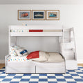 White wooden bunk bed with car-themed bedding, red throw and vintage car wall art in boys bedroom with blue checkered rug