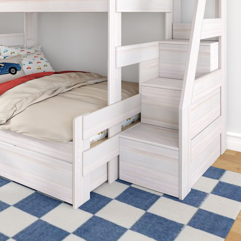 Whitewashed wooden bunk bed with built-in storage stairs, beige bedding and car-print pillow in a kids' bedroom on blue checkered rug