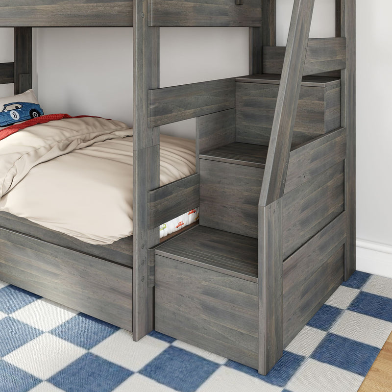 Gray wood twin-over-twin bunk bed with built-in storage stairs and ladder, beige bedding, blue race car pillow and checkered blue rug in kids' bedroom