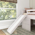White wooden kids loft bed with slide, blush pillows and bunny plush beside a large window with plaid Roman shade in a bright neutral bedroom