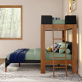Modern wooden loft bunk bed with ladder, green bedding and navy throw, striped accent pillows in a bright kids' bedroom with large window and forest view
