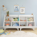 White children's bookshelf in pastel blue nursery with hanging bear and "Don't grow up" prints, wooden toys, stacking rings, children's books, plush cloud pillow and floor lamp
