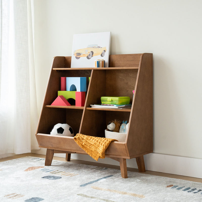 Kids wooden toy organizer shelf with colorful building blocks, soccer ball, stuffed lion, green lunchbox, yellow blanket and car artwork in a modern nursery