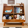 Wooden kids bookshelf with blue toy airplane, rows of children's books, plush stuffed animals and a personalized name plaque — neutral nursery decor and toy storage