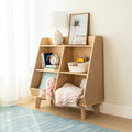 Wooden cubby shelf in bright nursery with ceramic lamp, framed palm print, alarm clock, children's books, Crayola crayons, plush octopus and pastel blankets