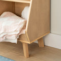 Plush pastel pink and white towels folded on an oak wooden shelf bench beside a hardwood bathroom floor