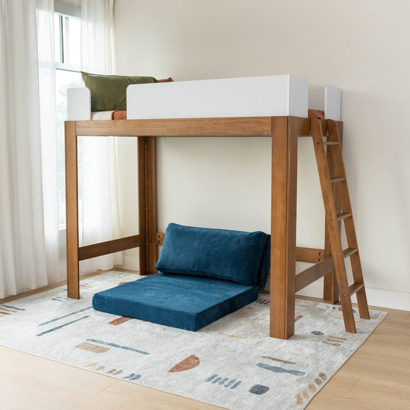 Wooden loft bed with ladder and white safety rail, blue floor cushions and patterned area rug in sunlit modern kids' bedroom with sheer curtains