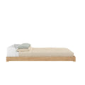 Modern wooden platform bed with white low headboard, beige textured duvet and green gingham pillows