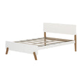 White wooden platform bed frame with slatted base, minimalist headboard and mid‑century modern oak legs — modern bedroom furniture