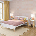 Pastel children's bedroom with pink bedding, yellow curtains, arch-pattern wallpaper, white wooden bed, bedside lamps and plush bunny toy.