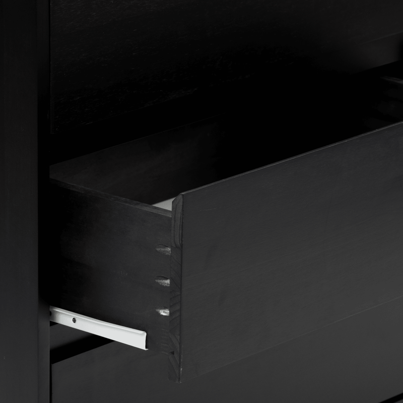 Close-up of a modern matte black wooden dresser drawer partially open, showing the drawer front, joinery detail and white metal drawer slide