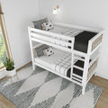 White wooden bunk bed in modern kids bedroom with black-and-white bedding, patterned pillows, wall sconce and potted plant