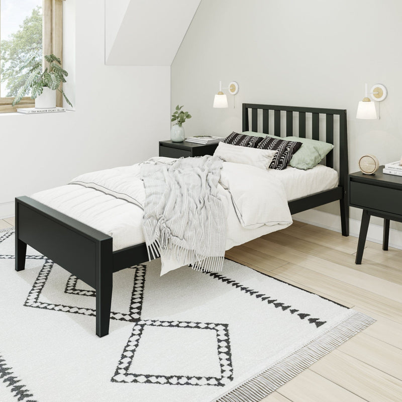 Minimalist Scandinavian bedroom with black platform bed, white bedding and textured throw, black-and-white geometric rug, nightstands, wall sconces and potted plant by window
