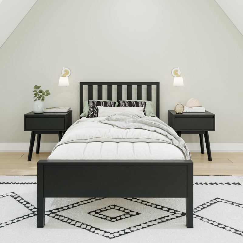 Modern minimalist Scandinavian bedroom with black wooden bed frame, matching nightstands, neutral white bedding, patterned rug, wall sconces and potted plant