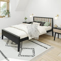 Minimalist Scandinavian bedroom with black wood platform bed, neutral bedding, patterned geometric rug, wooden nightstands, wall sconces and potted plant by window