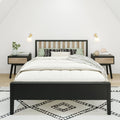 Minimal Scandinavian bedroom interior with black wood bed frame, white bedding, green and patterned pillows, matching nightstands, wall sconces, potted plant and geometric rug