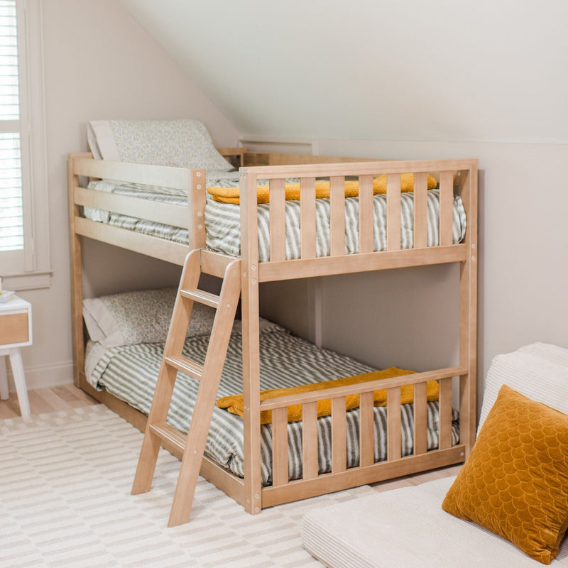 Natural wood bunk bed with ladder in a neutral kids' bedroom, striped bedding and mustard yellow throw blanket