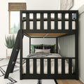 Modern black metal loft bunk bed with ladder, upper twin mattress and lower cozy bed with green pillows in a bright kids' bedroom with potted succulent