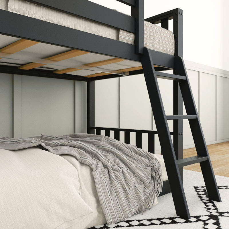 Modern black metal loft bunk bed with ladder and wooden slats, lower bed with beige linens and gray striped throw in a bright minimalist bedroom